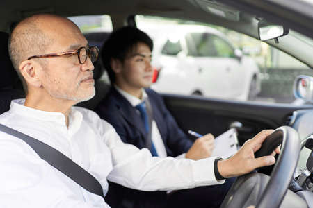 Elderly people taking training in driving a carの写真素材