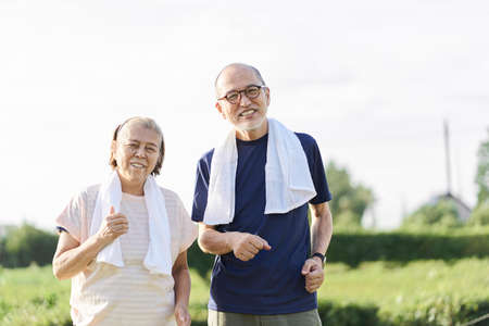 Elderly Asians jogging outside in the eveningの写真素材