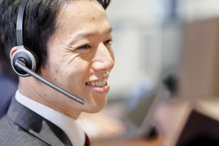 Asian business person responding at the customer centerの写真素材