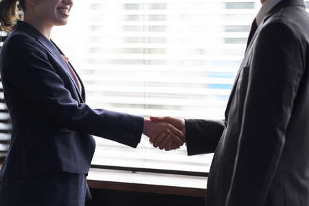 Asian business person shaking handsの写真素材
