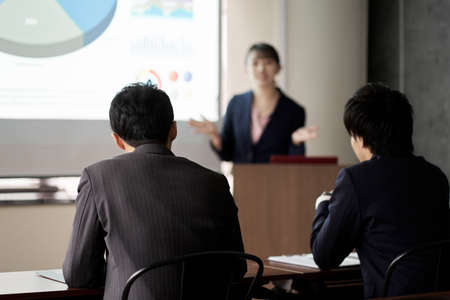 Asian businessman listening to a presentation at a meeting