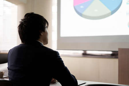 Asian businessman listening to a presentation at a meetingの写真素材
