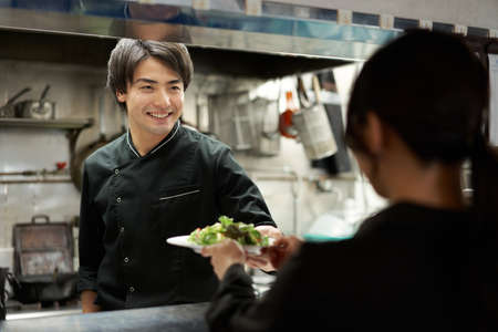Asian cook cooking in a restaurantの写真素材