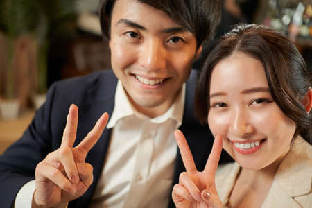 Asian couple making peace signsの写真素材