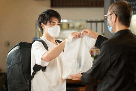 Asian man receiving a meal to deliver
