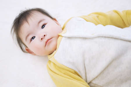 Asian baby with a serious look when waking upの写真素材