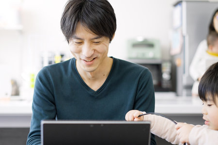 Asian man disturbed by children's teleworkの写真素材