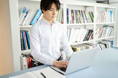 Male construction management engineer who organizes materials on a laptop computerの写真素材