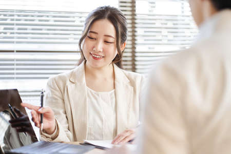 Asian business woman explaining on a laptopの写真素材