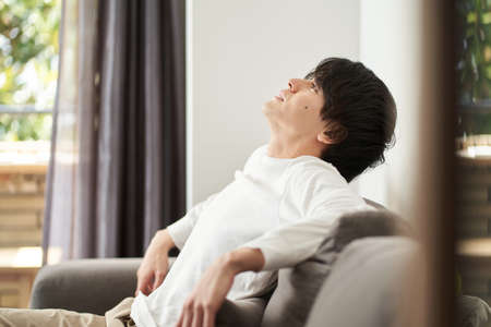 Asian man relaxing in the living roomの写真素材