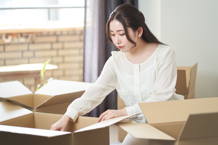 Asian woman packing for movingの写真素材