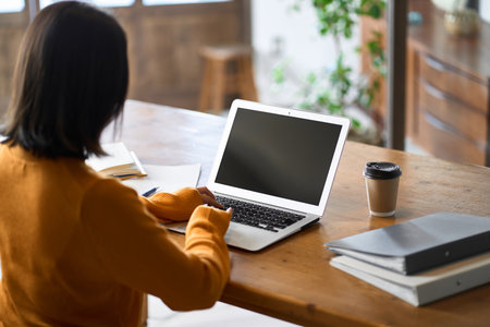 Back view of an Asian woman doing teleworkの写真素材