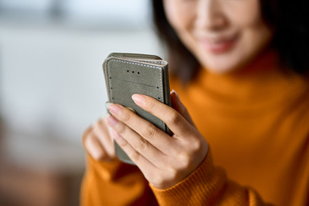 A woman using a smartphone with a smileの写真素材