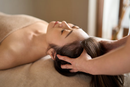 Woman receiving head massage at beauty salonの写真素材