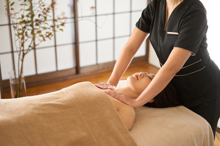 Woman receiving decollete massage at beauty salonの写真素材