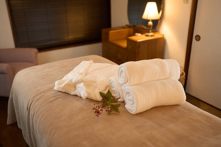 Gowns and towels on the bed in the beauty salonの写真素材