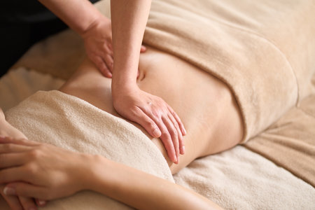 A woman receiving a belly massage at a beauty salonの写真素材