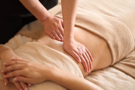 A woman receiving a belly massage at a beauty salonの写真素材