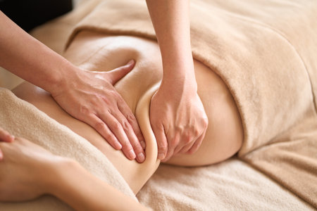 A woman receiving a belly massage at a beauty salonの写真素材