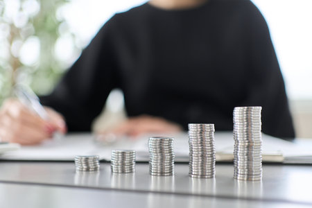 A woman studying investment and a coin stackの写真素材