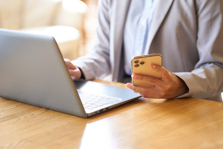 Hand of an Asian woman operating a computer at a cafeの写真素材