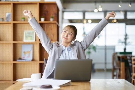 Asian woman stretching while workingの写真素材