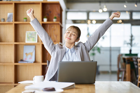 Asian woman stretching while workingの写真素材
