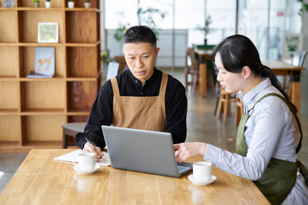 An Asian couple talking about cafe management policyの写真素材
