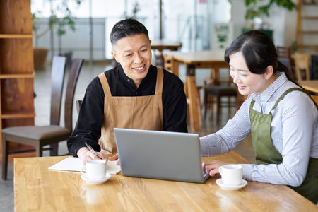 An Asian couple talking about cafe management policyの写真素材