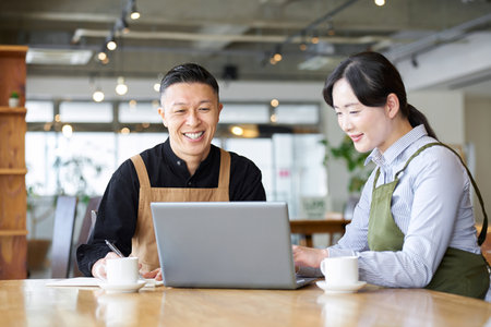An Asian couple talking about cafe management policyの写真素材