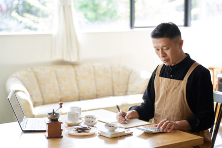 Asian businessman calculating the cost of productsの写真素材