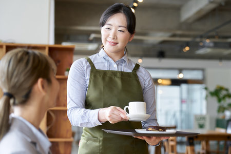 Asian female clerk working at a cafeの写真素材