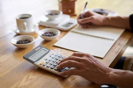 Asian man calculating the cost of coffeeの写真素材