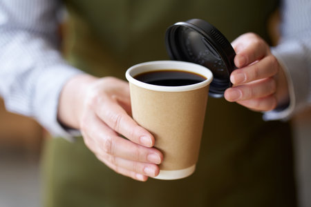 Hand of a cafe clerk offering coffeeの写真素材