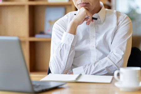 Asian businessman thinking while working at a cafeの写真素材