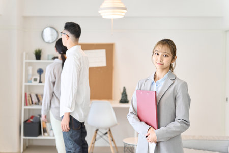 A real estate sales woman showing around the roomの写真素材