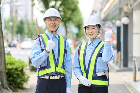 Asian male and female security guards doing fist pumpsの写真素材