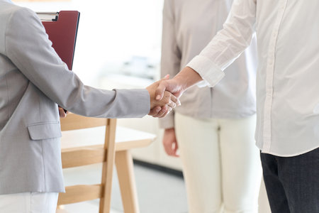 A man and a woman shake hands after closing a real estate dealの写真素材