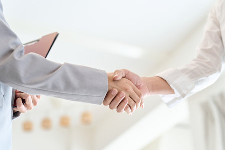 A man and a woman shake hands after closing a real estate dealの写真素材