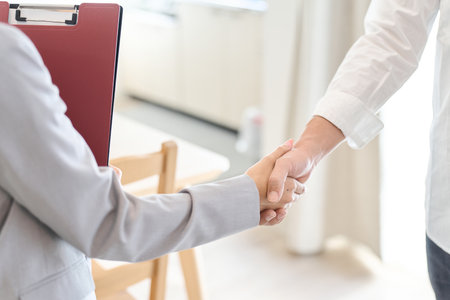A man and a woman shake hands after closing a real estate dealの写真素材