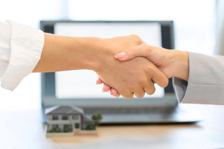 A man and a woman shaking hands during a real estate contractの写真素材