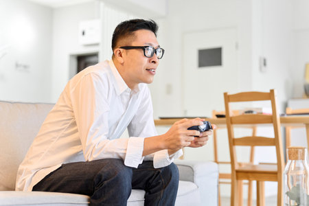 Asian man playing games in the living room