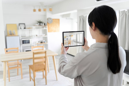 A woman using an AR app to simulate furniture placementの写真素材