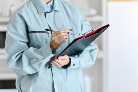 A professional woman comes to your home wearing work clothes to conduct an assessment.の写真素材