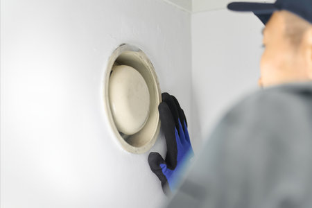 Male worker checking the ventilation fanの写真素材