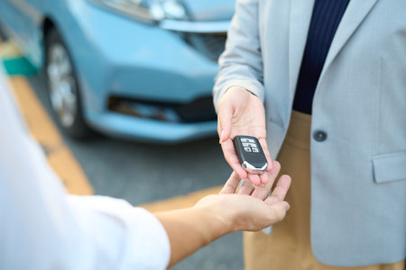 Woman handing over car keys outsideの写真素材