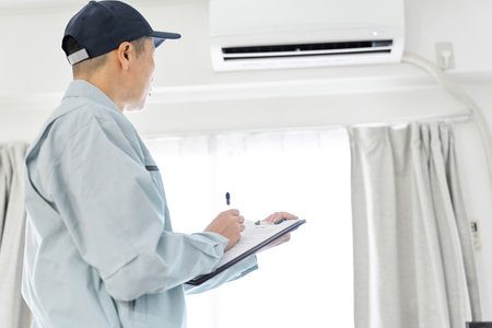Asian worker inspecting air conditionerの写真素材