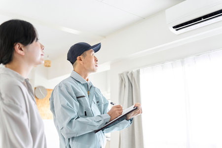 Asian worker inspecting air conditionerの写真素材