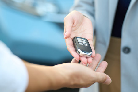 Woman handing over car keys outsideの写真素材