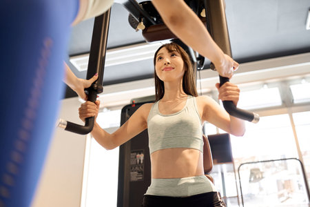 Woman training her chest muscles with a pectoral fly machineの写真素材